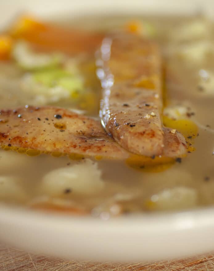 Bouillon de porc noir de Bigorre de Noël ravioles du Dauphiné, foie gras poêlé et légumes de saison